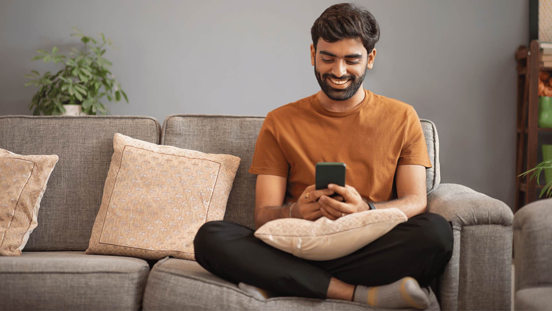 man sitting on the couch while on phone 