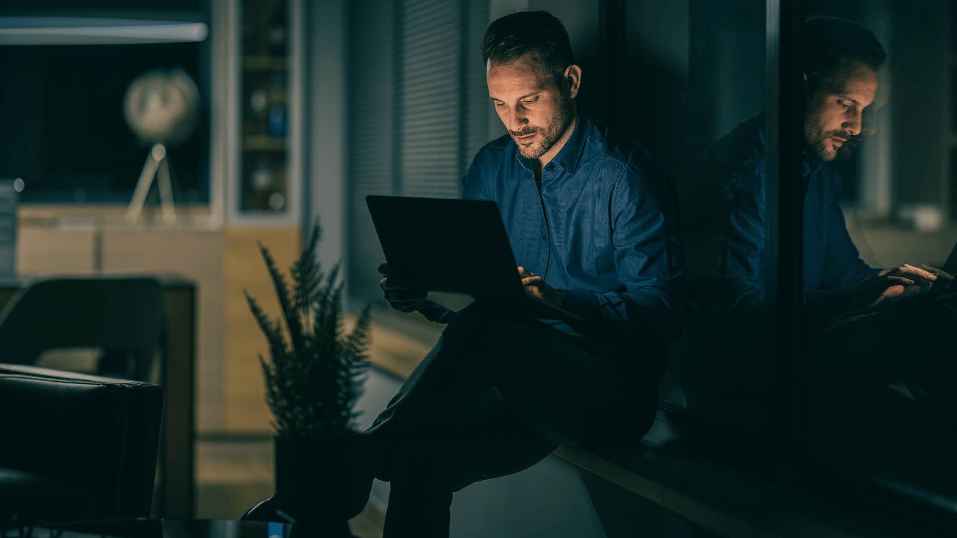 man working on laptop at night 