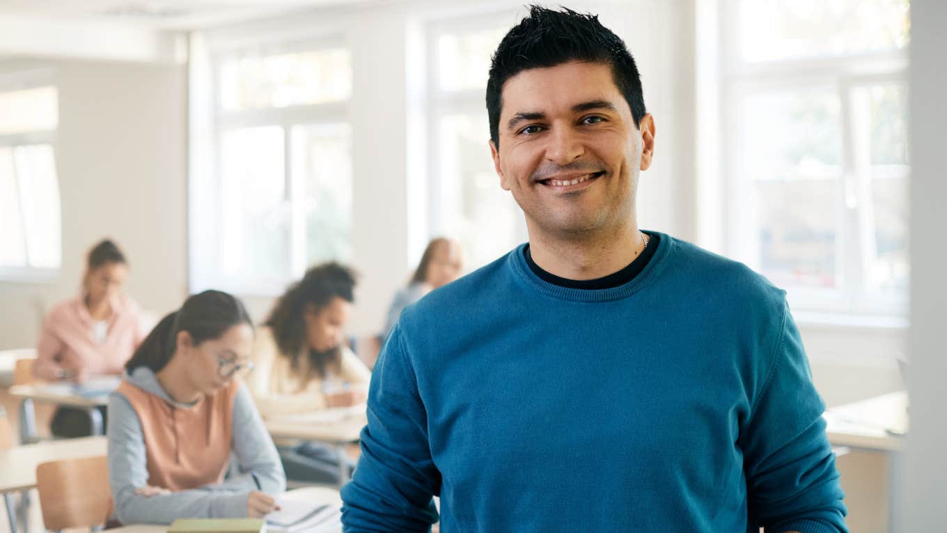 Male teacher wearing a t-shirt in his classroom. 