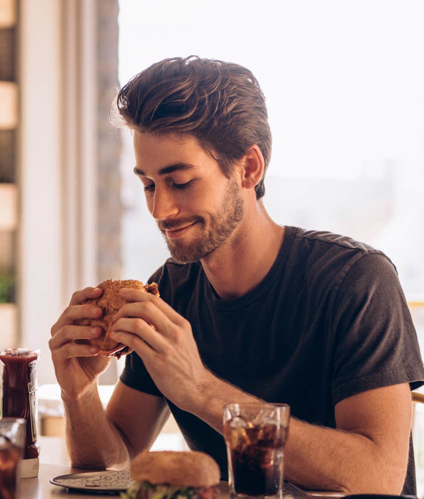 man about to bite into a burger