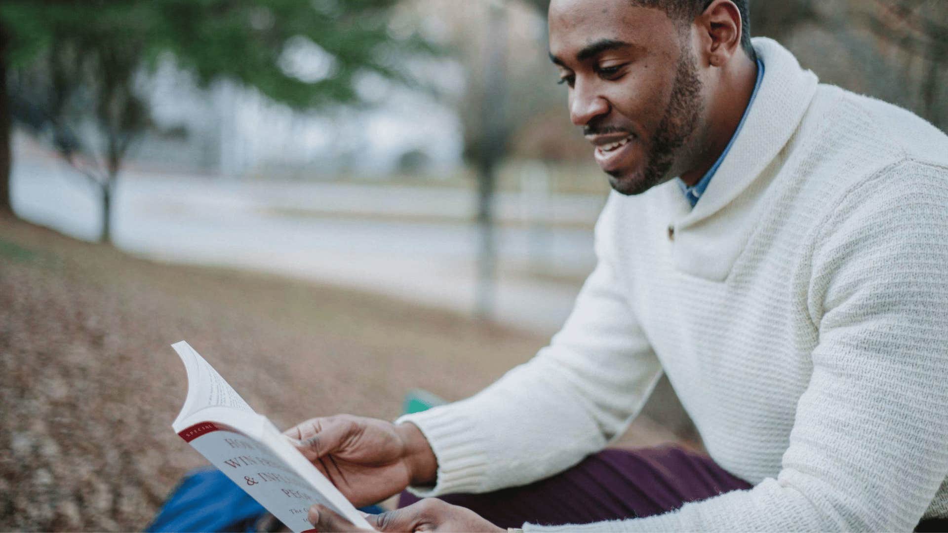 man reading while sitting outdoors