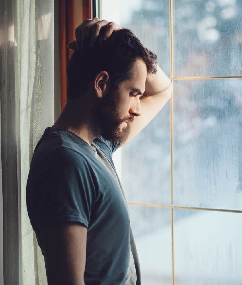 man reconsidering his marriage while looking out window