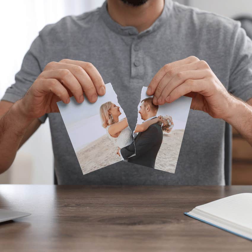 man ripping a photo of couple in half