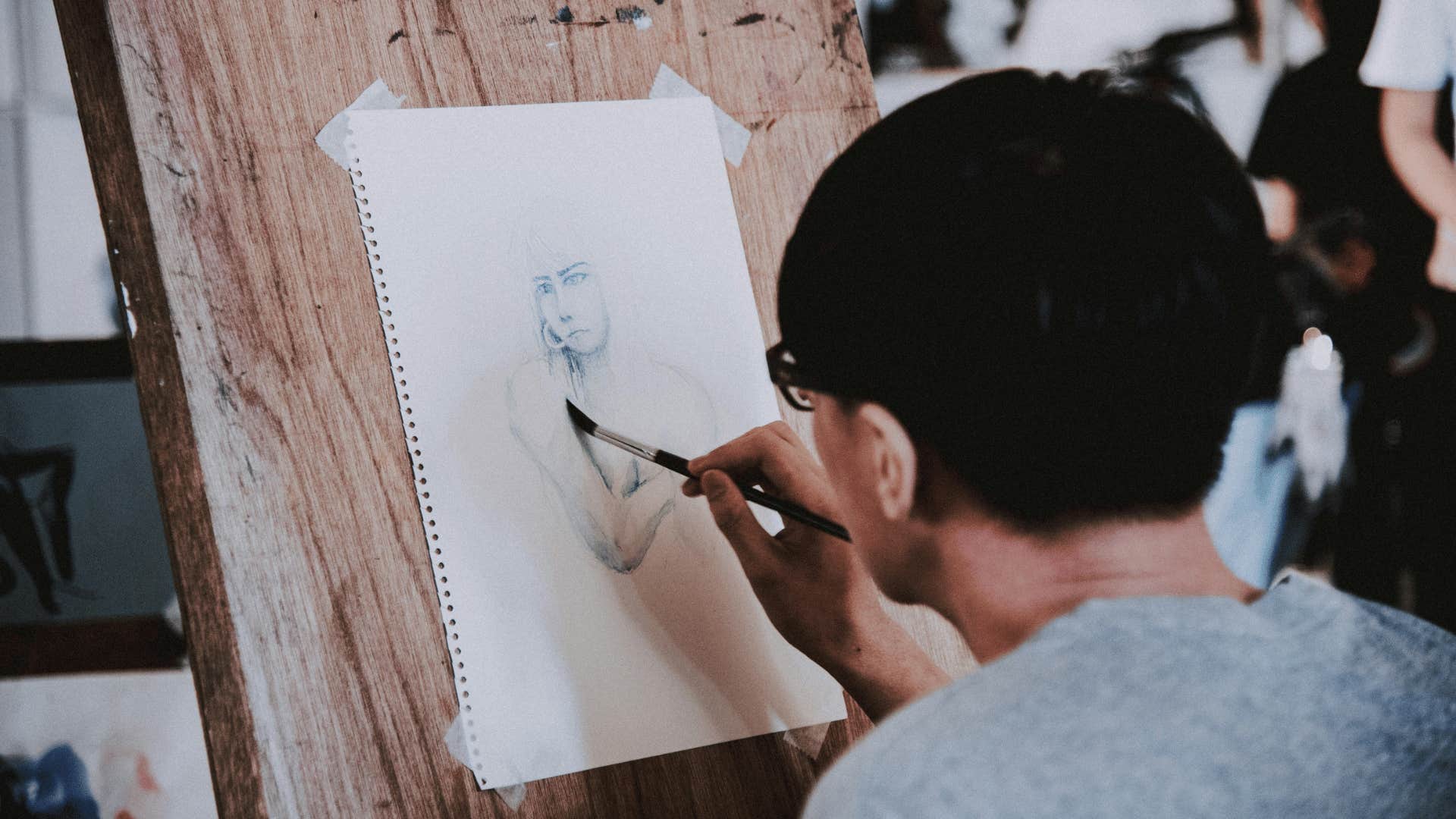 man sketching a drawing of a woman