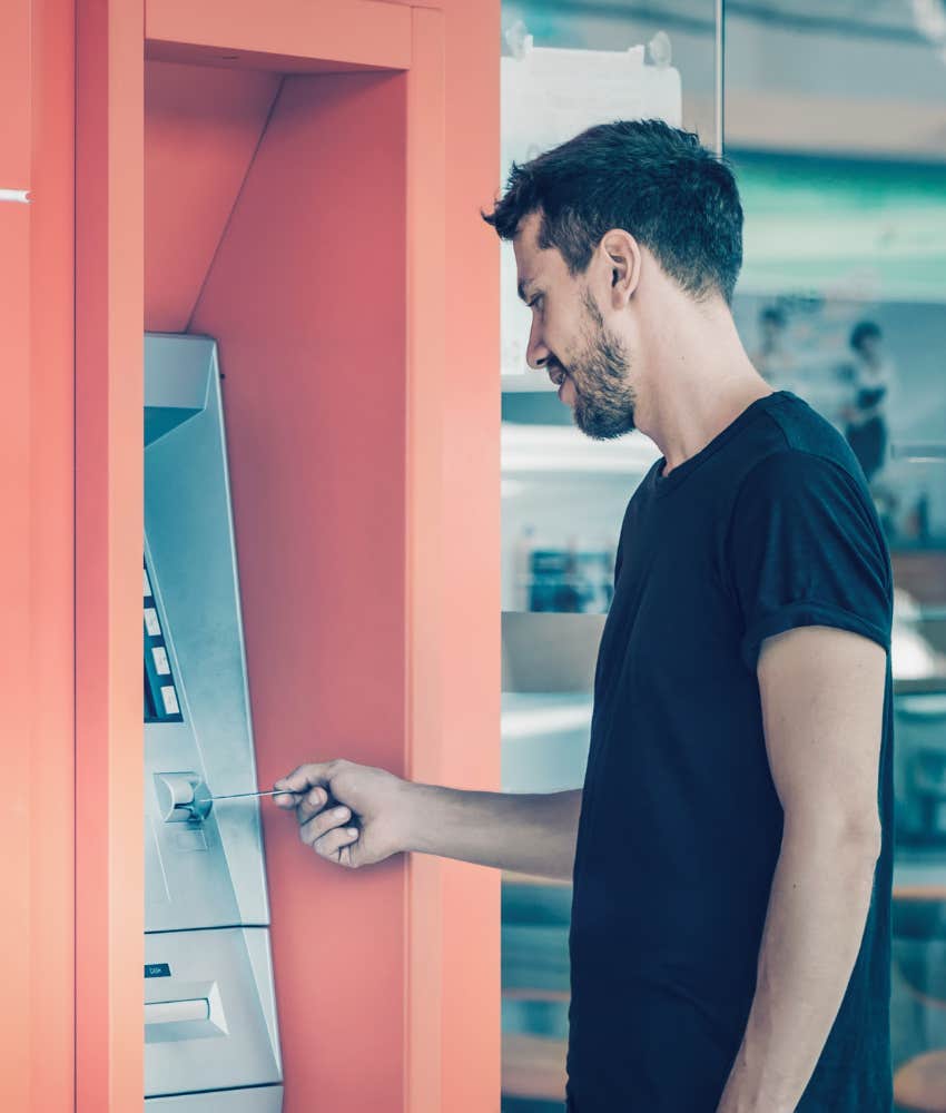 man putting bank card into atm