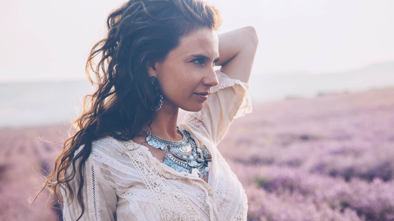 Beautiful woman in a field feeling contemplative