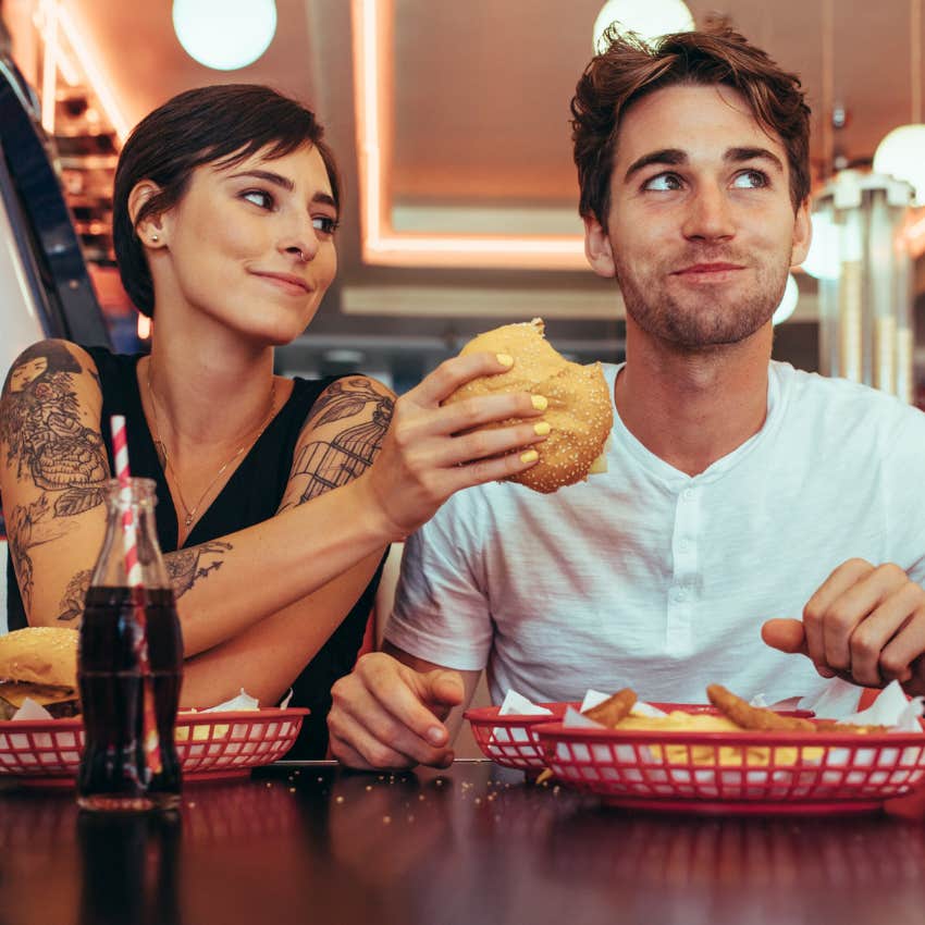 Married couple reenacting their first date at a chain restaurant. 