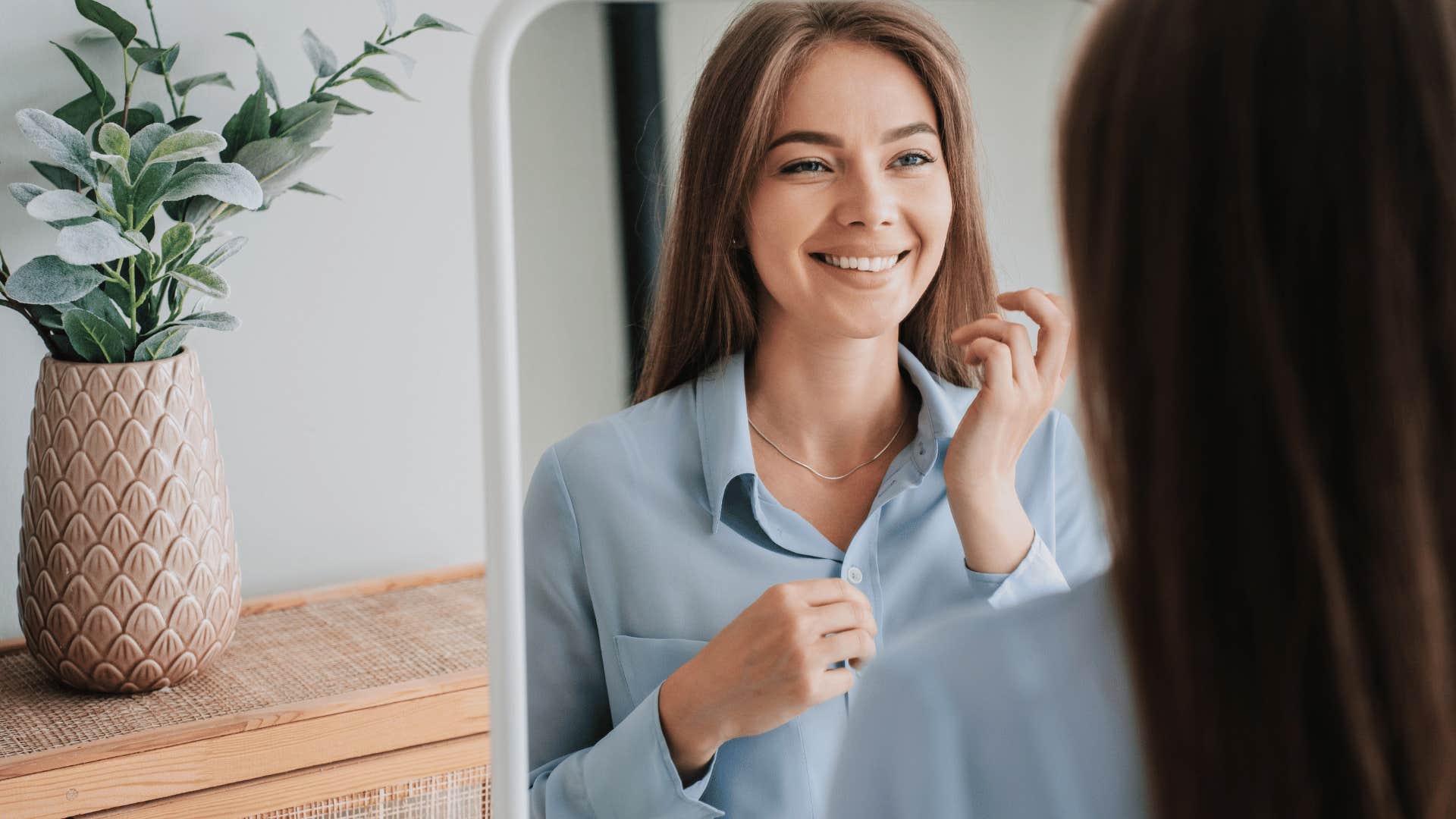 woman looking at mirror smiling 