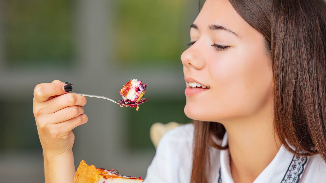 woman eating a slice of cheesecake