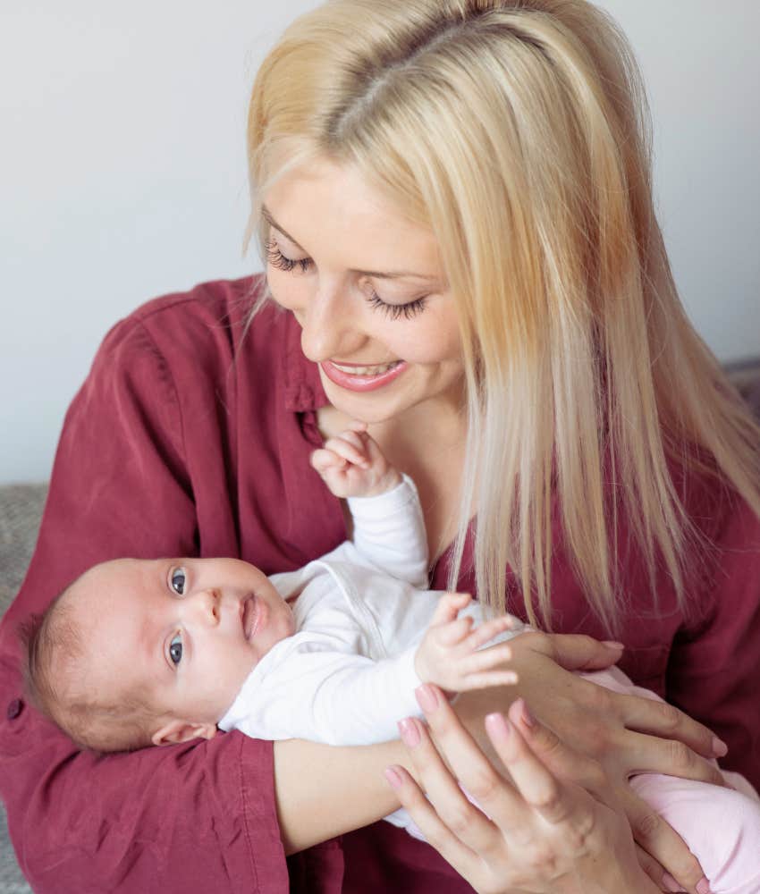 mom smiling at newborn baby