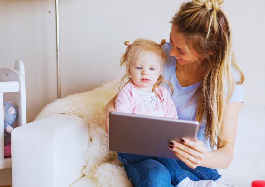 mom using a tablet with her toddler at home