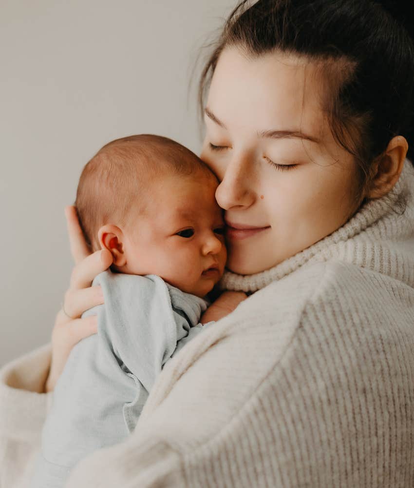 woman snuggling newborn boy