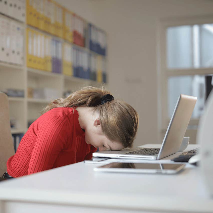 office woman resting her head on laptop