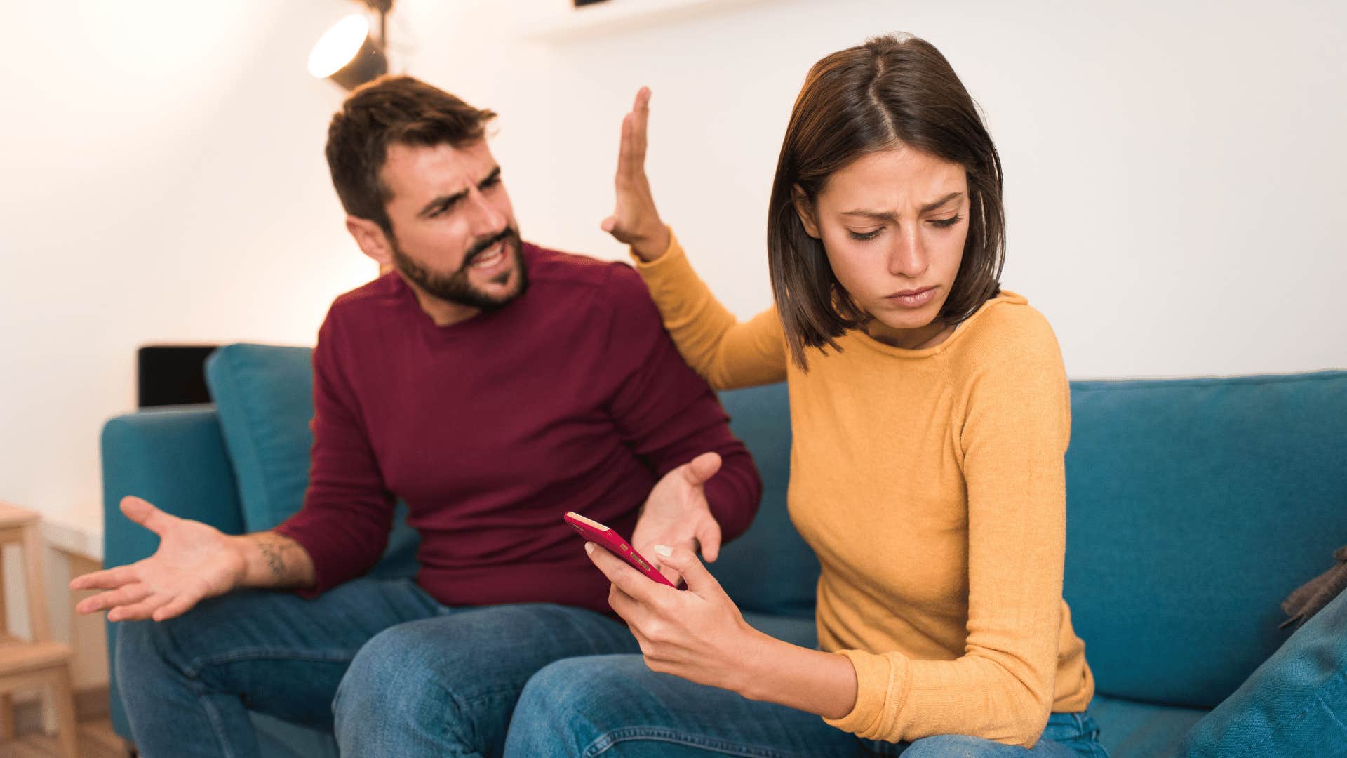 She holds a hand up to his face to stop him from speaking