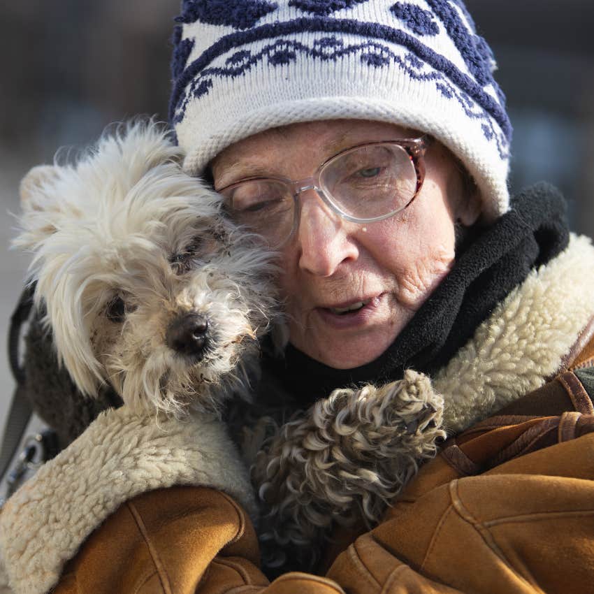 Old disabled dog being hugged by an older woman. 