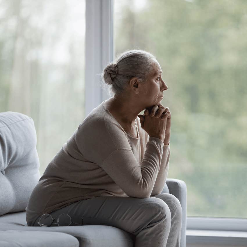 older woman sitting alone looking out of window