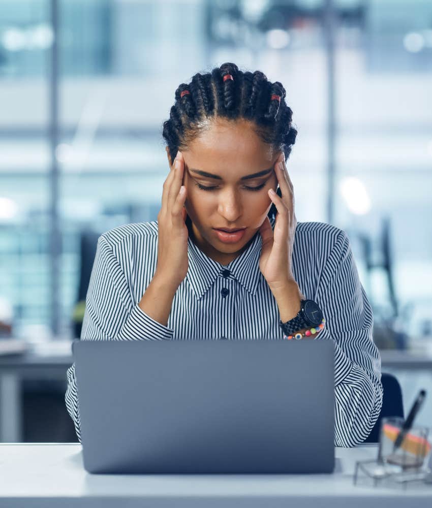 woman at computer holding her head