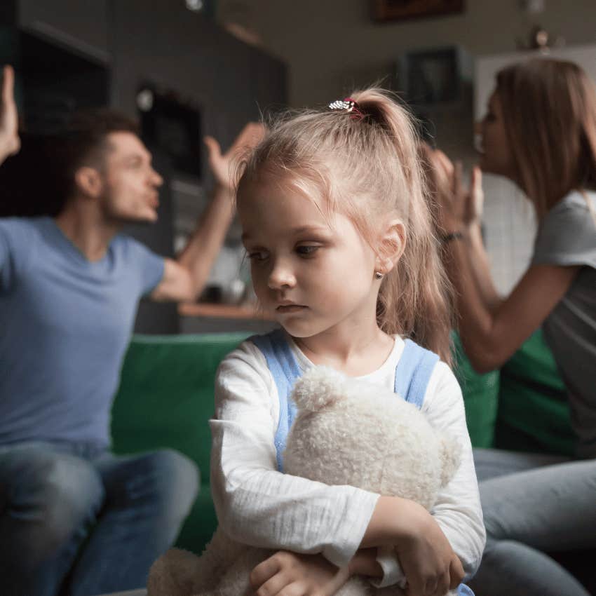 parents arguing behind sad young girl