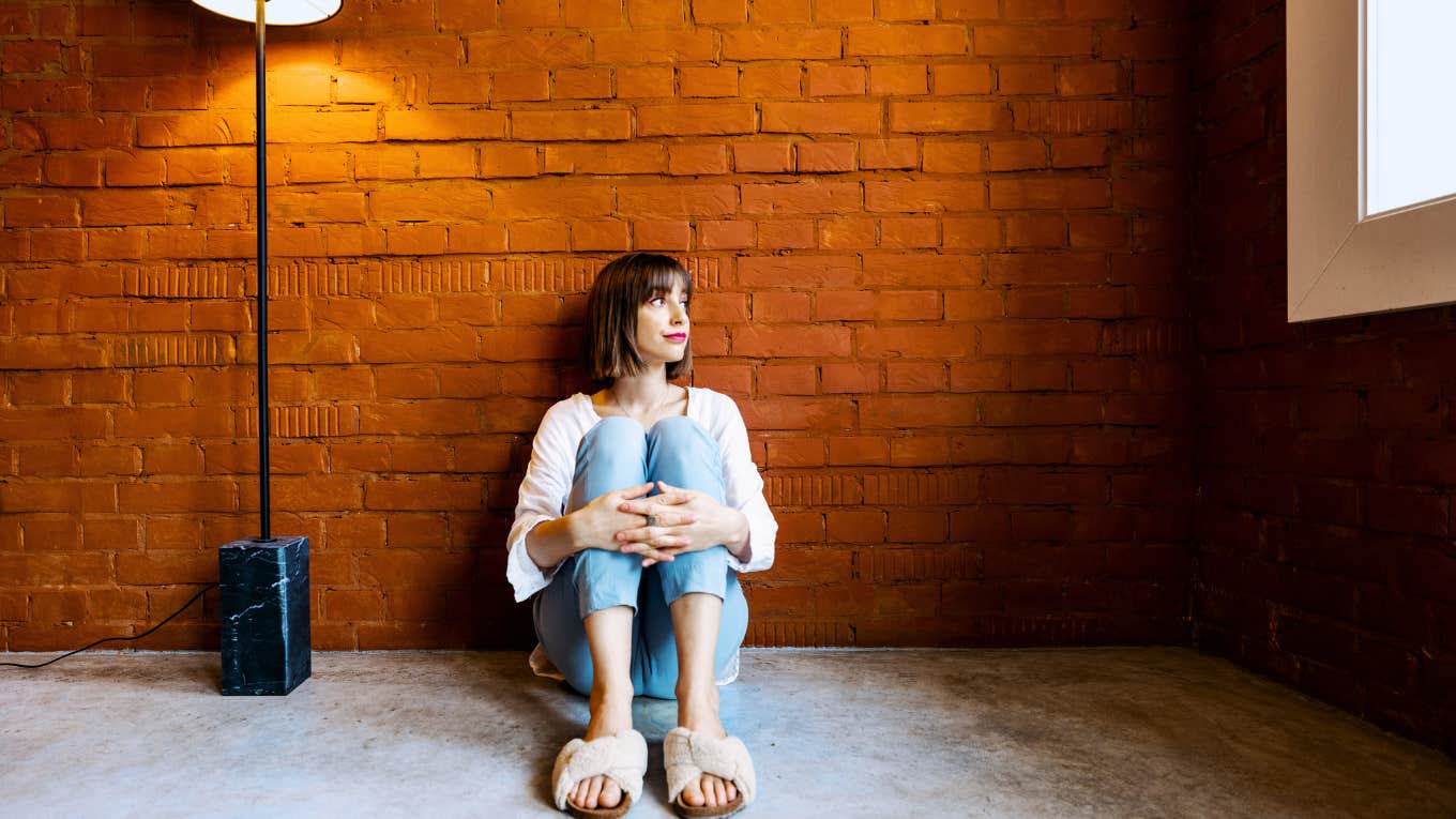 Unhappy single person leaning against wall.