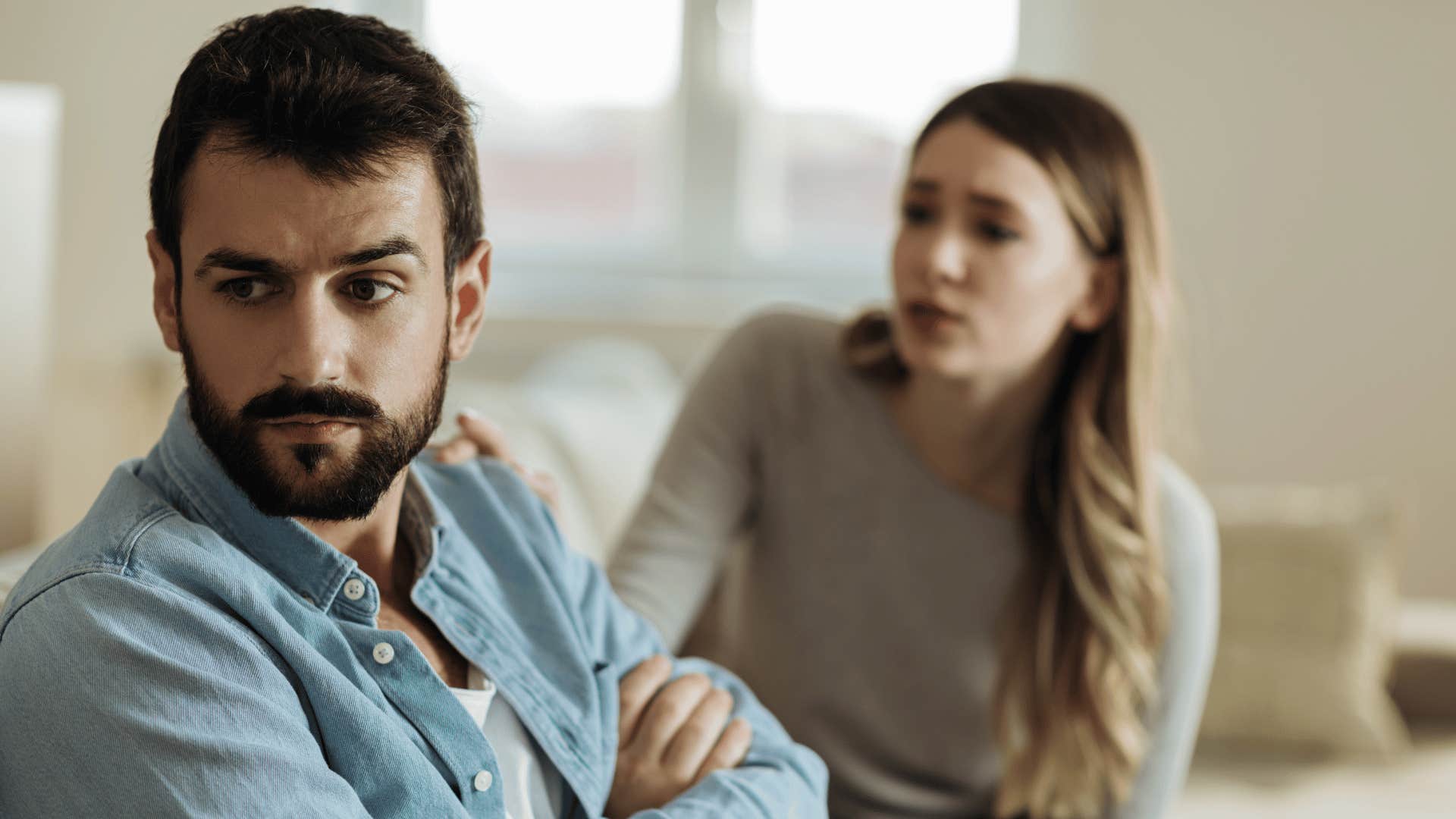 woman pleading with man while he ignores her 