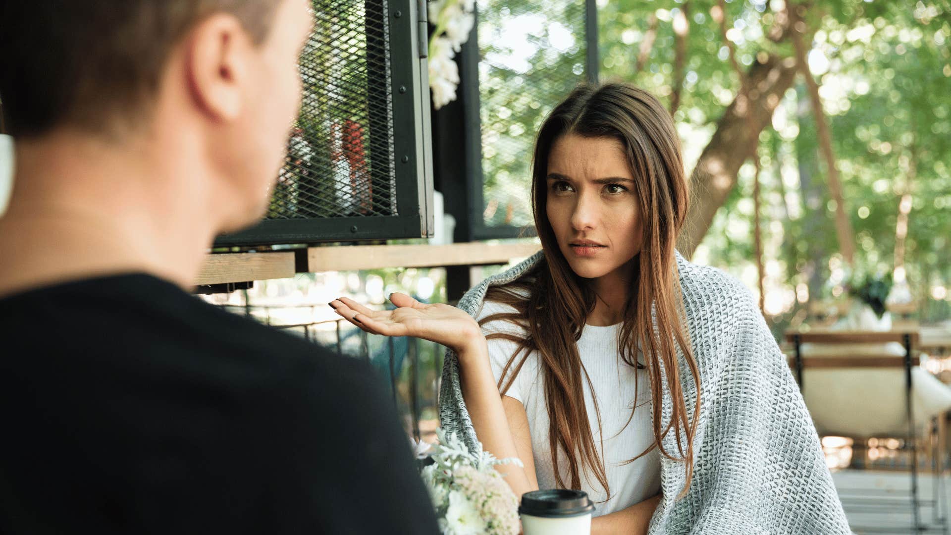 woman sitting with man and looking upset with man 