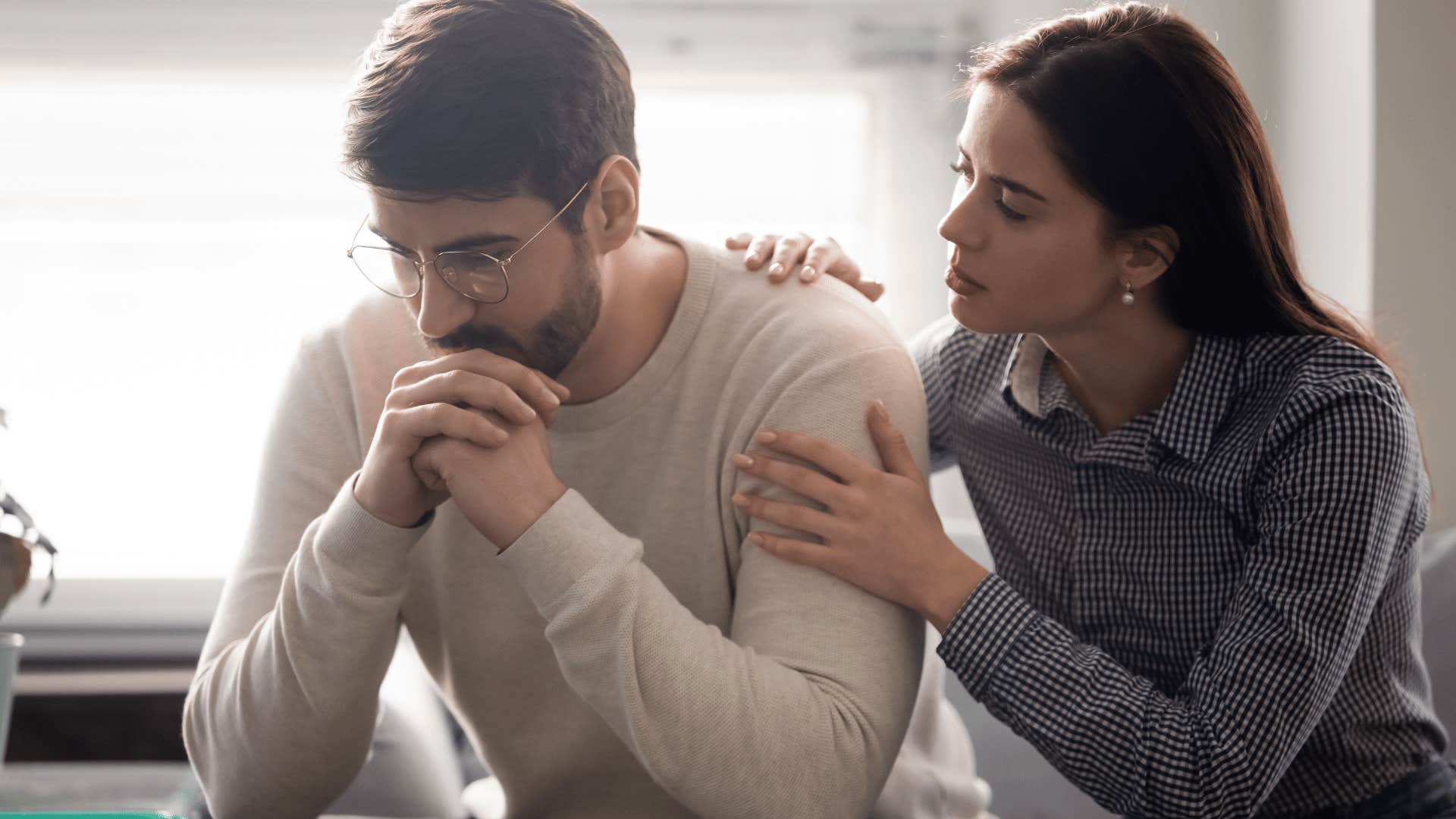 woman comforting man 