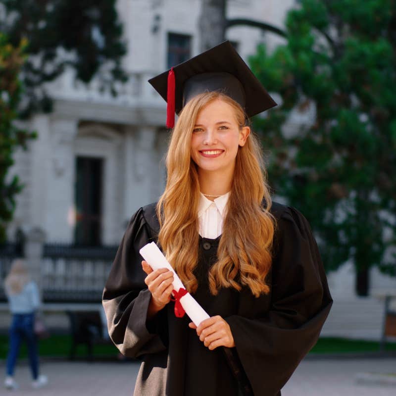 smiling college graduate holding diploma