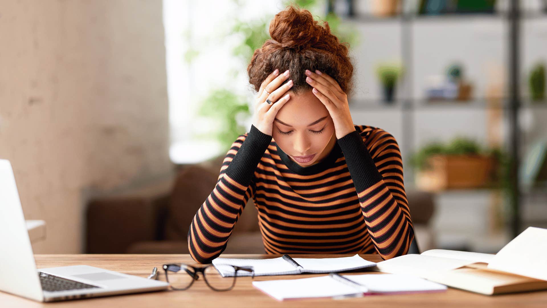 woman with head in hands looking stressed