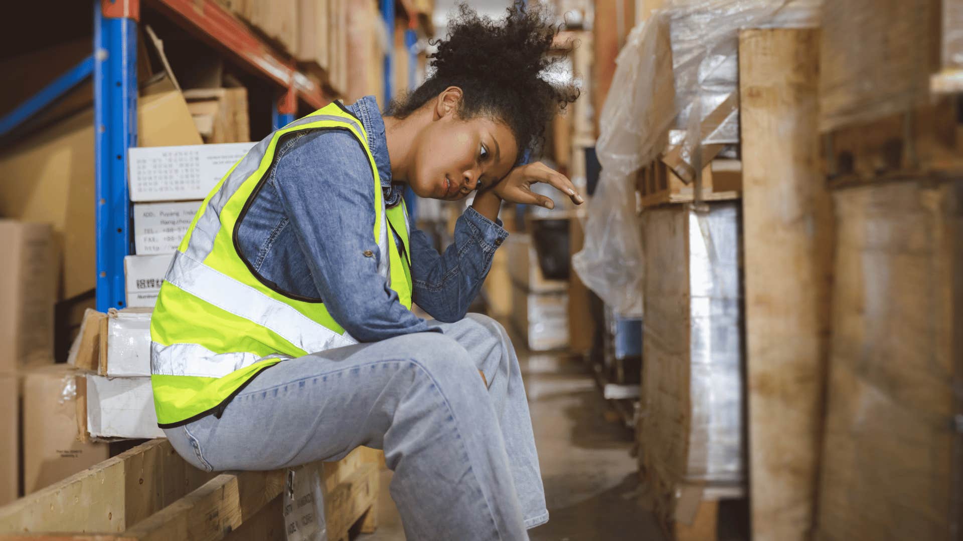 woman looking burnout and stressed while sitting down at work