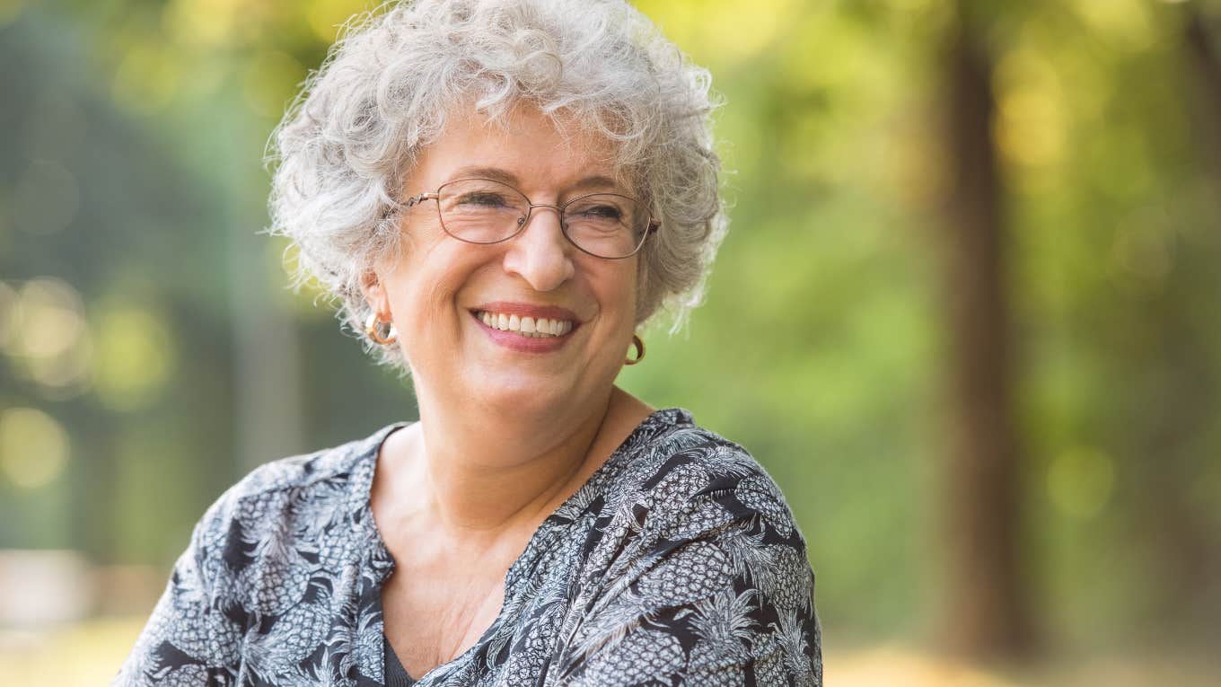 elderly woman smiling while sitting outside