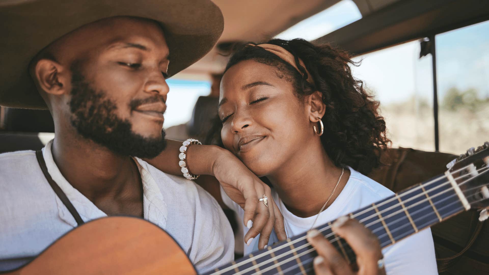 He plays guitar while she rests on his shoulder