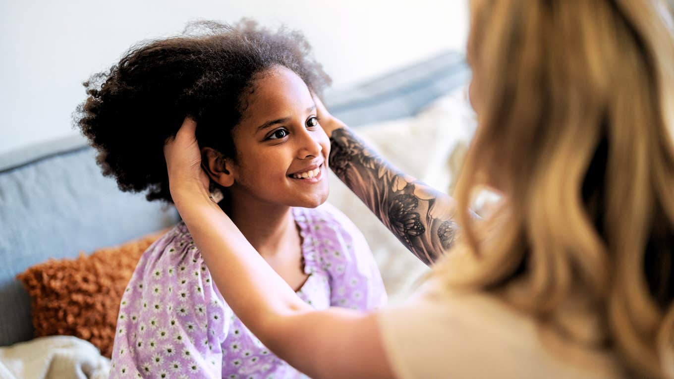 Mother braiding her daughters ethnic hair 