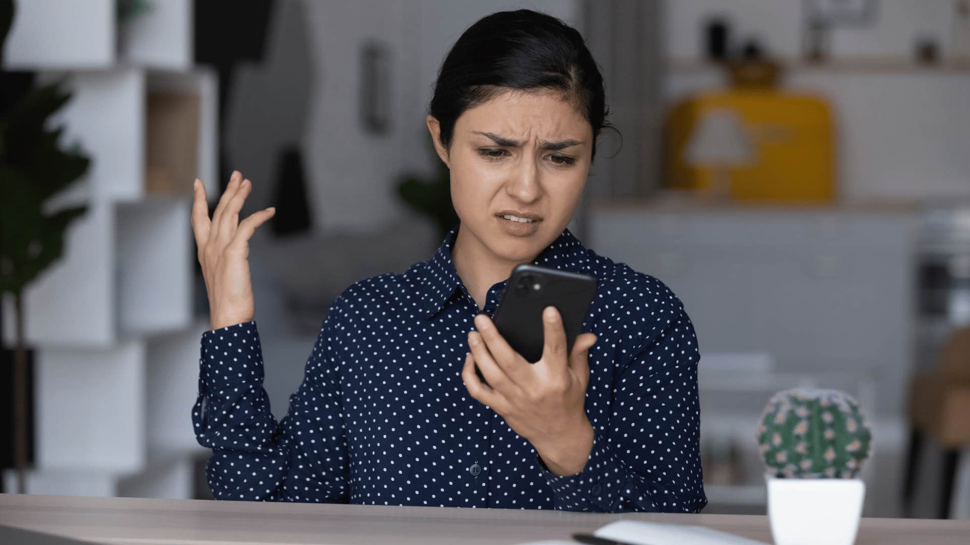 woman looking upset while staring at phone 