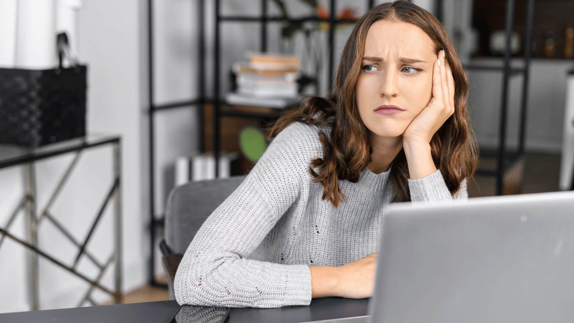 woman with head in hand looking upset 