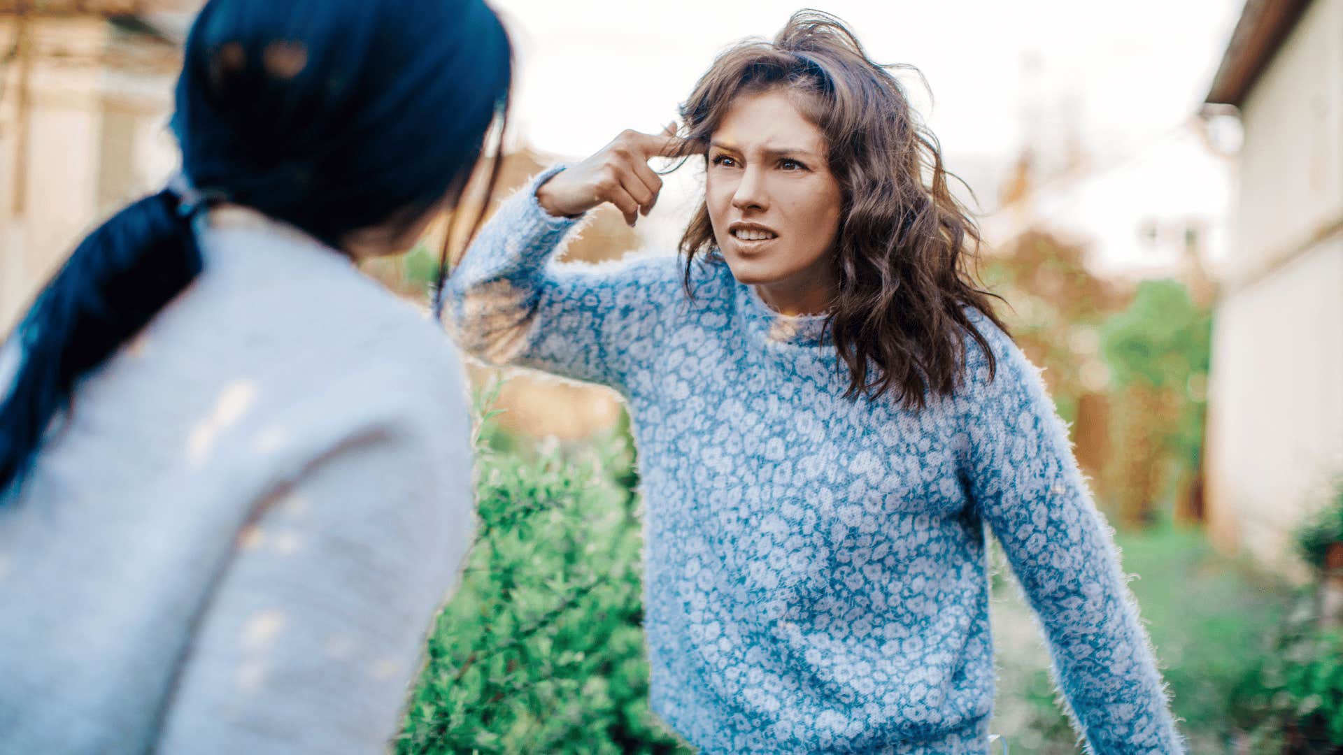 woman arguing and pointing at her head