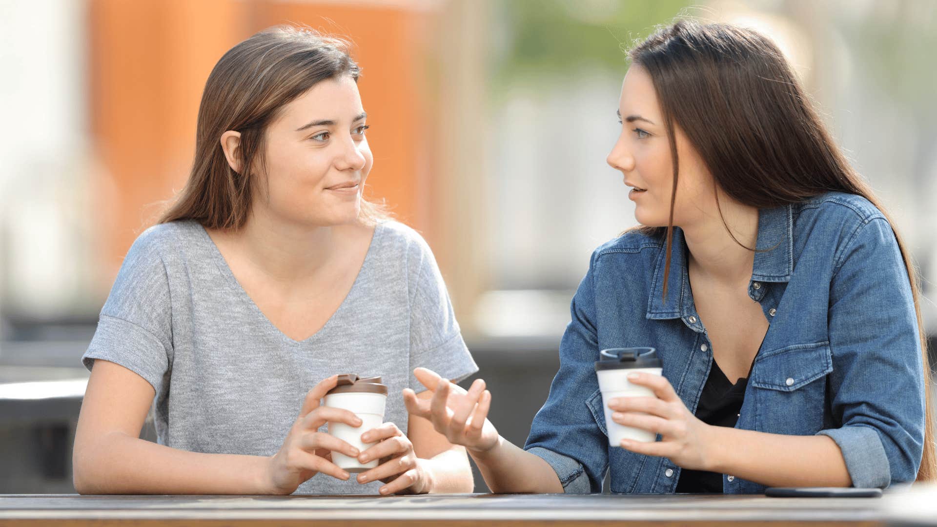 two women talking and drinking coffee