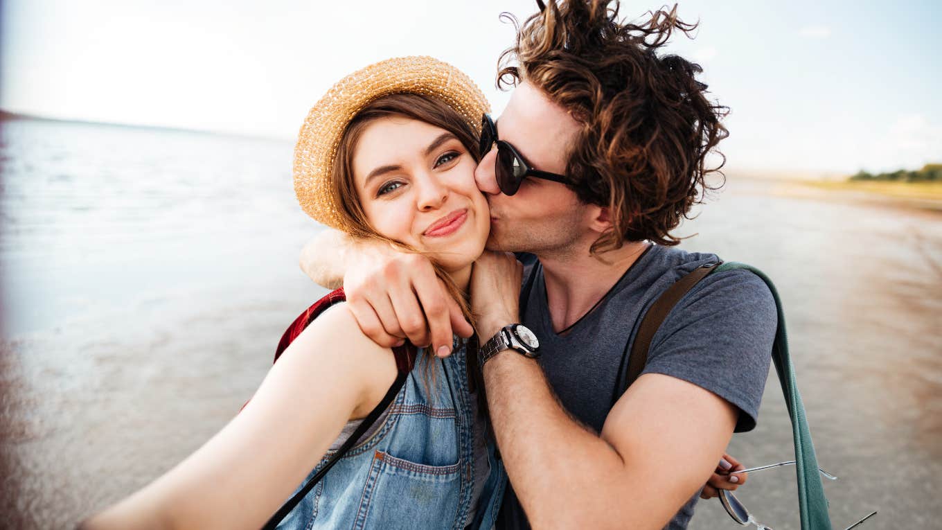 Man really into woman, kissing cheek.