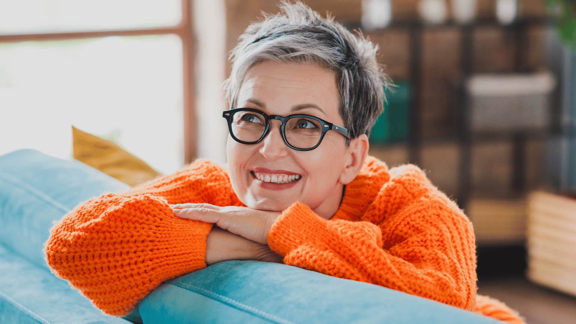 woman smiling while sitting on blue sofa