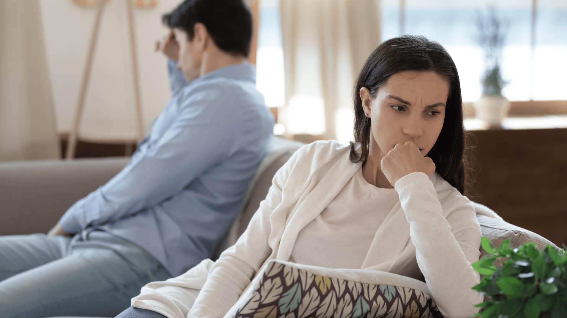 woman ignoring man while sitting on couch