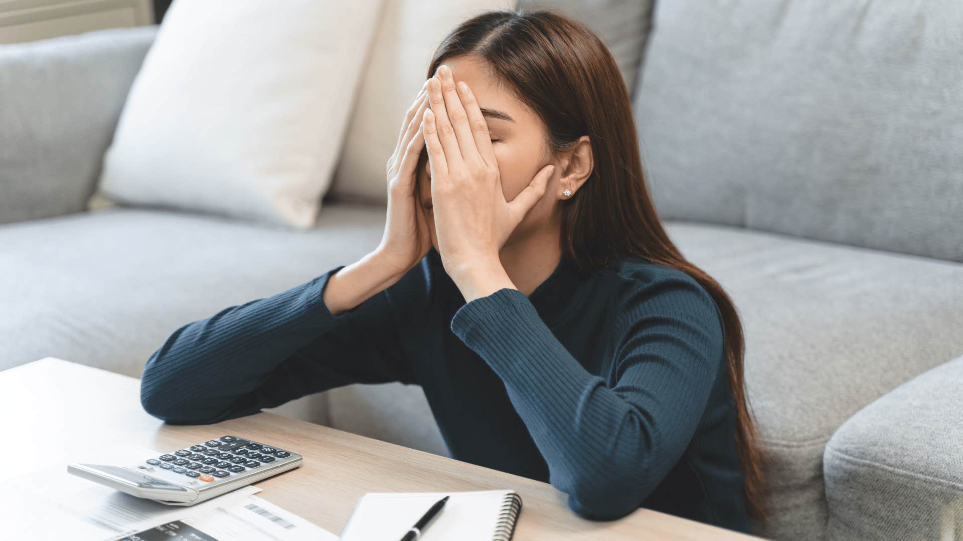 woman covering her face looking stressed