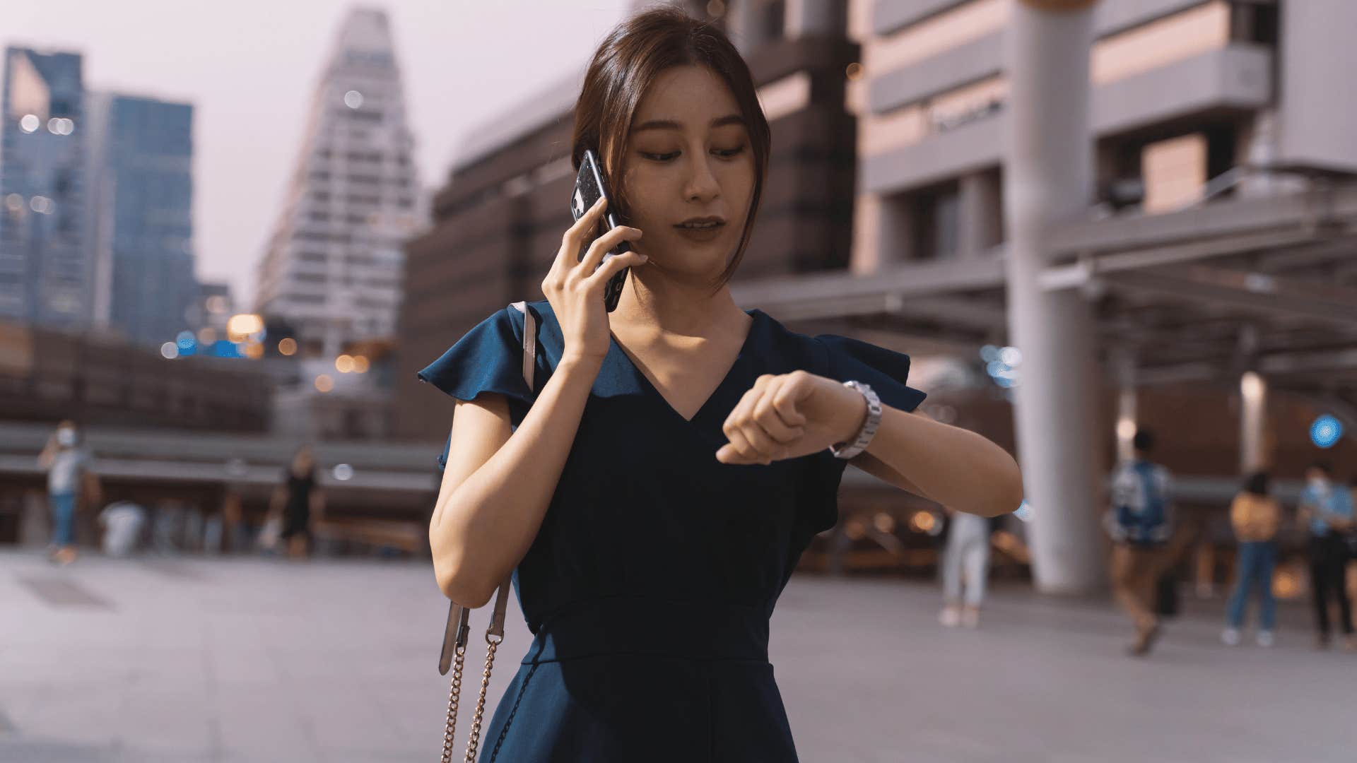 woman checking watch while on phone 