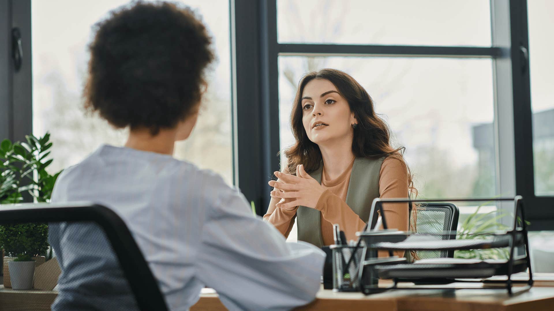 two women discussing something in office