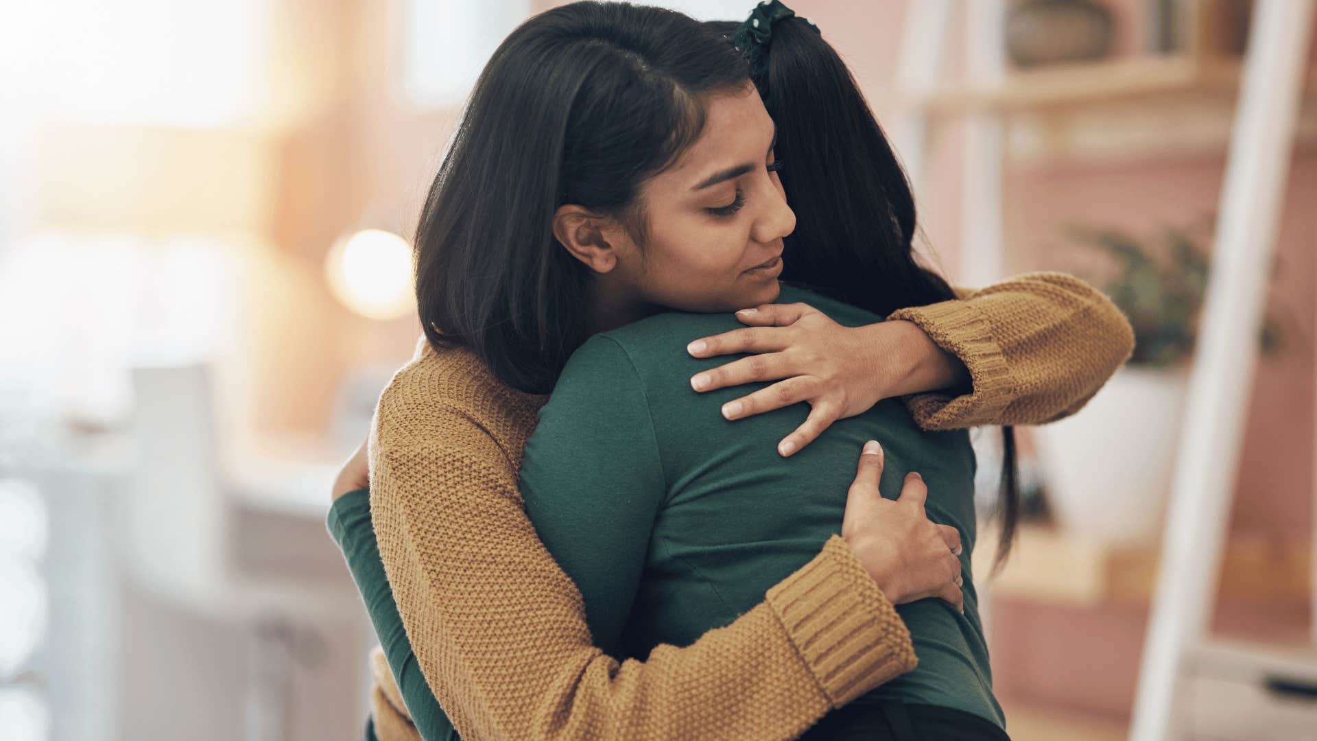 two women hugging outside