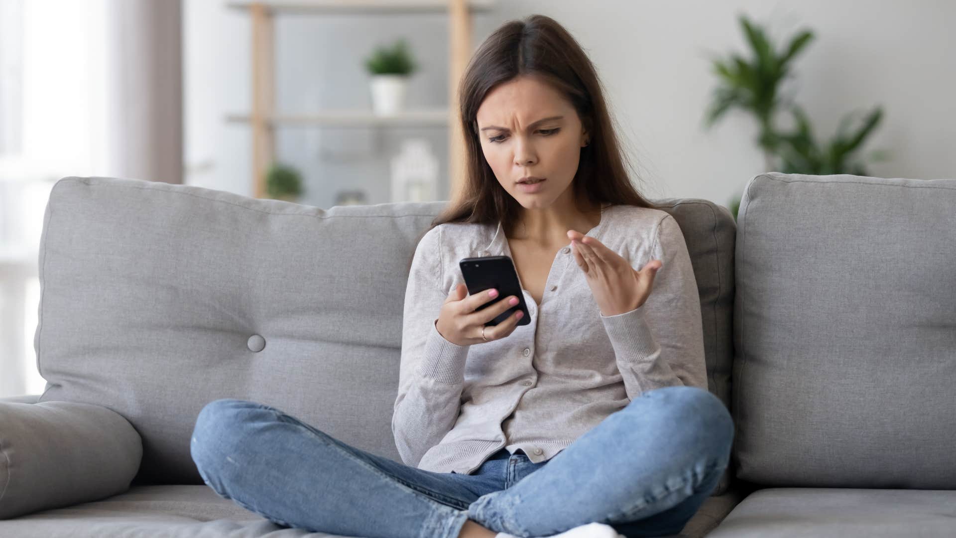 woman looking at phone upset 