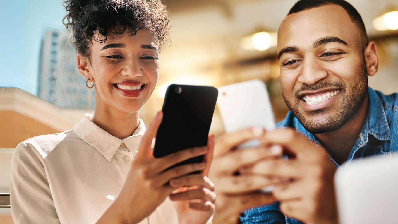 Two people on dating app, smiling at phone 