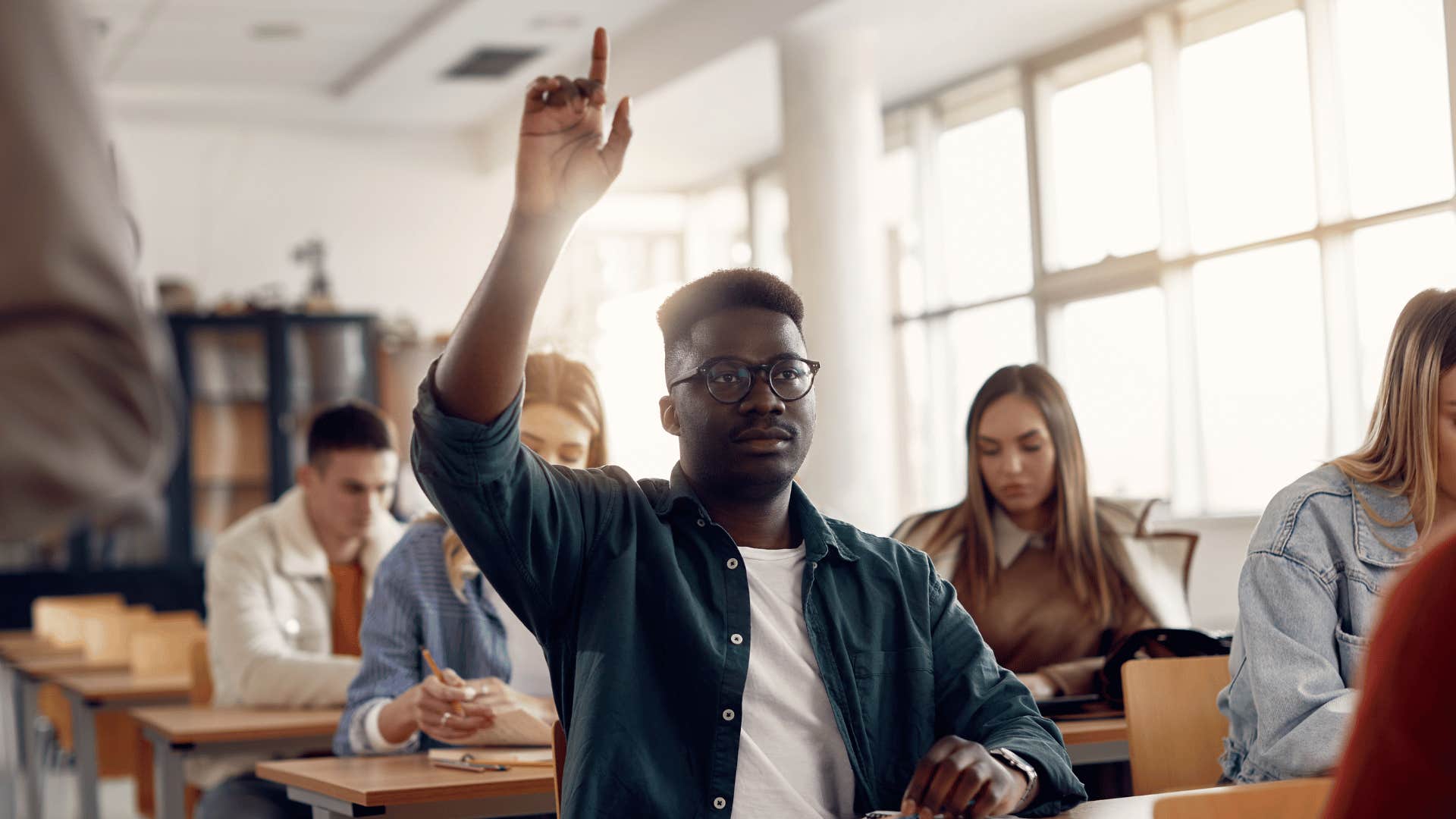 man raising his hand in a classroom