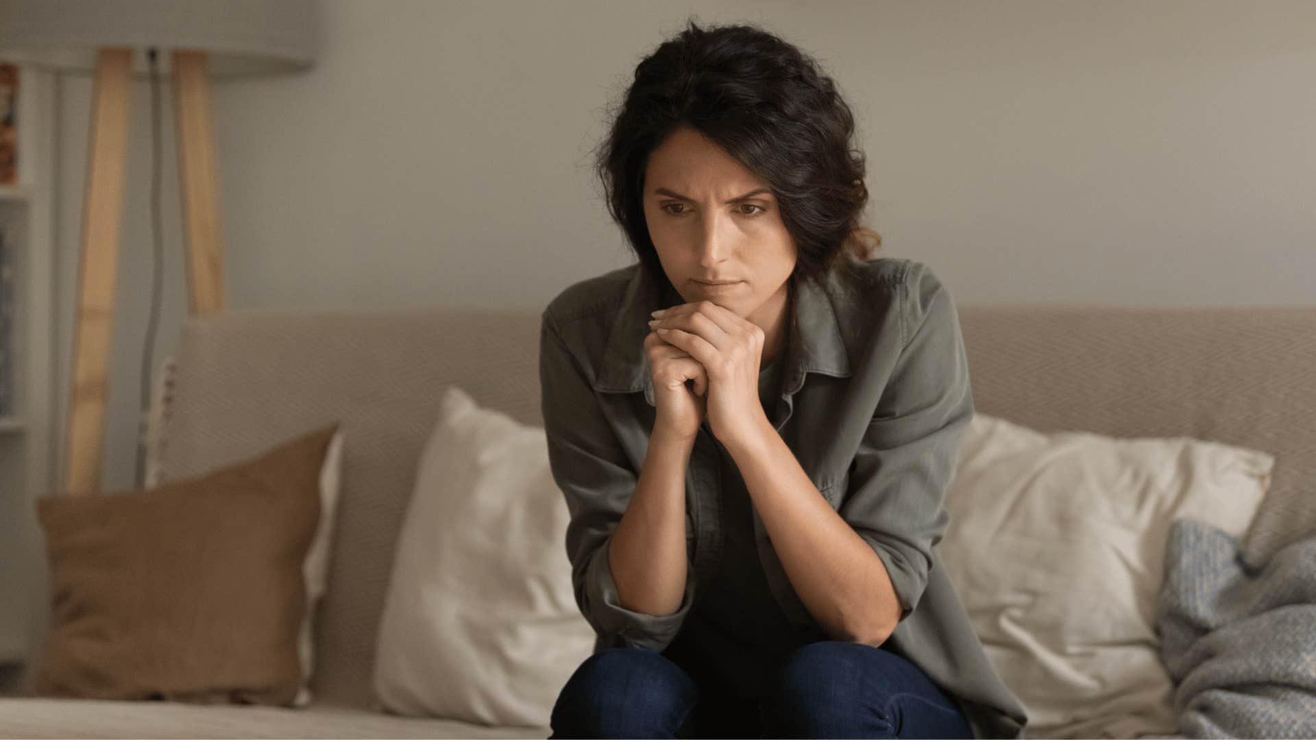 woman contemplating while sitting on couch