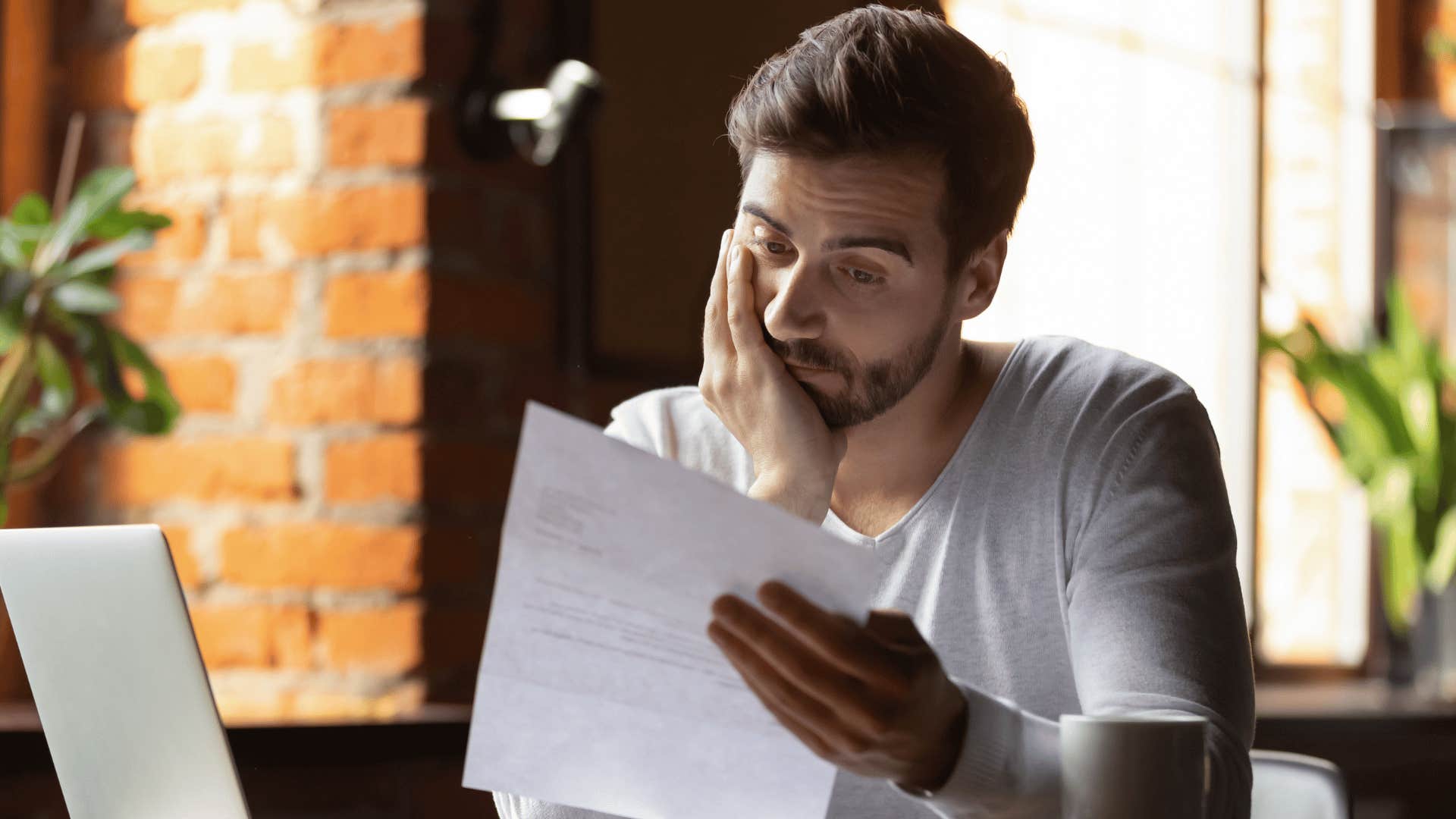 man looking at documents unhappily 