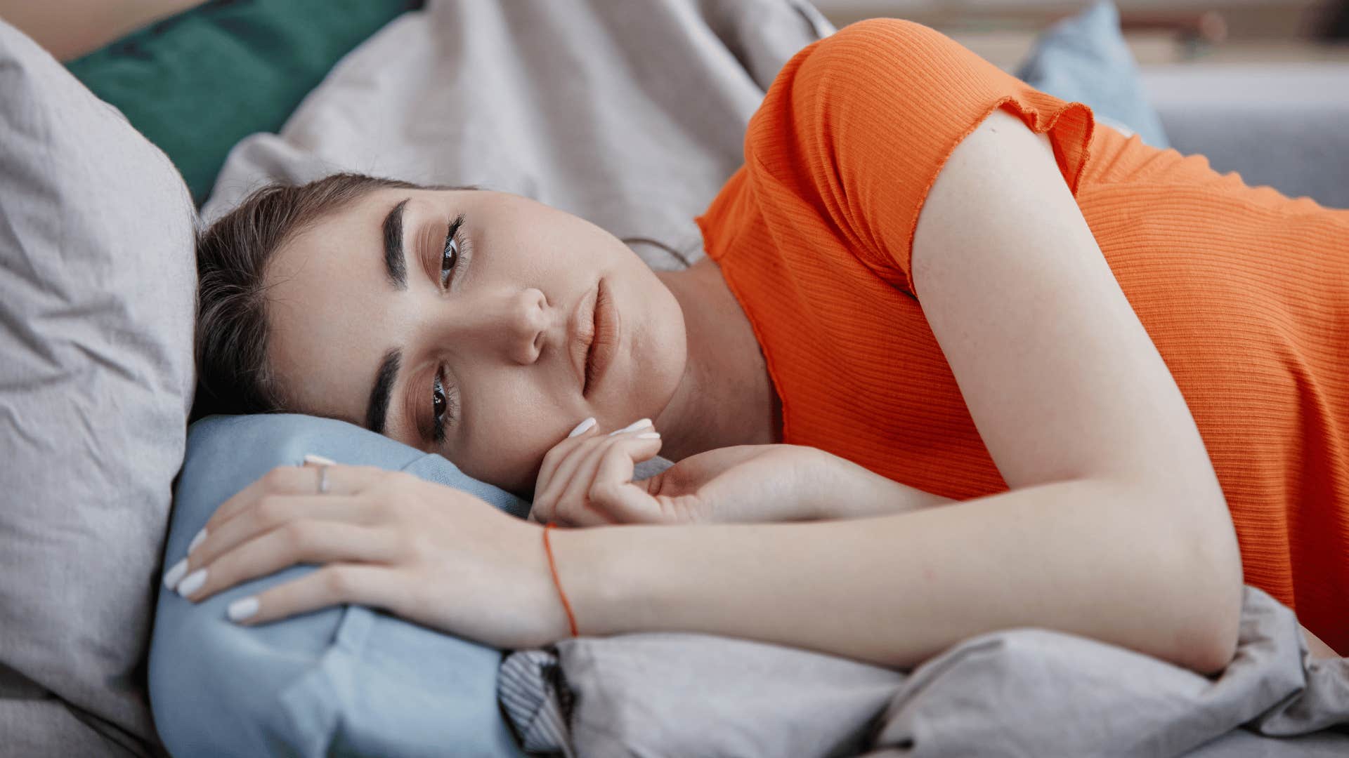 woman laying on bed depressed