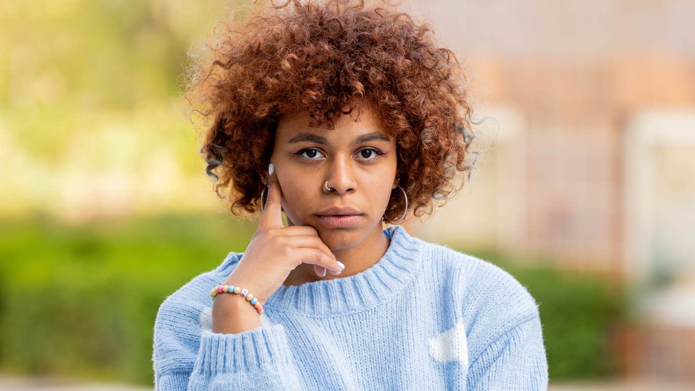 serious woman with hand on face thinking